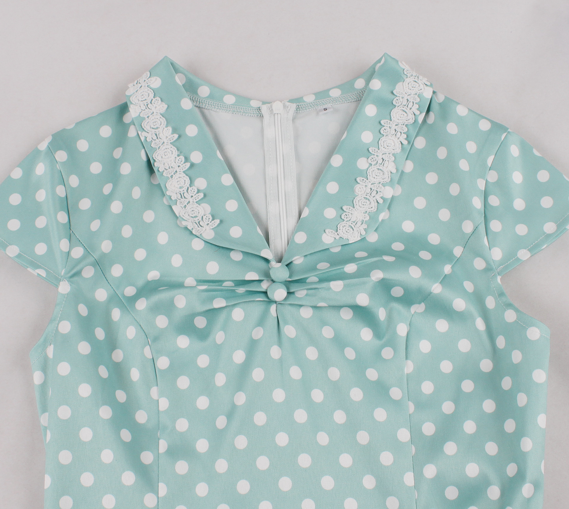 Vintage style, Green with white polka dots, Short sleeves, V-neckline, White lace trim, Chest bow accent, Cinched waist belt, A-line skirt, Lightweight fabric, Comfortable fit #N23827