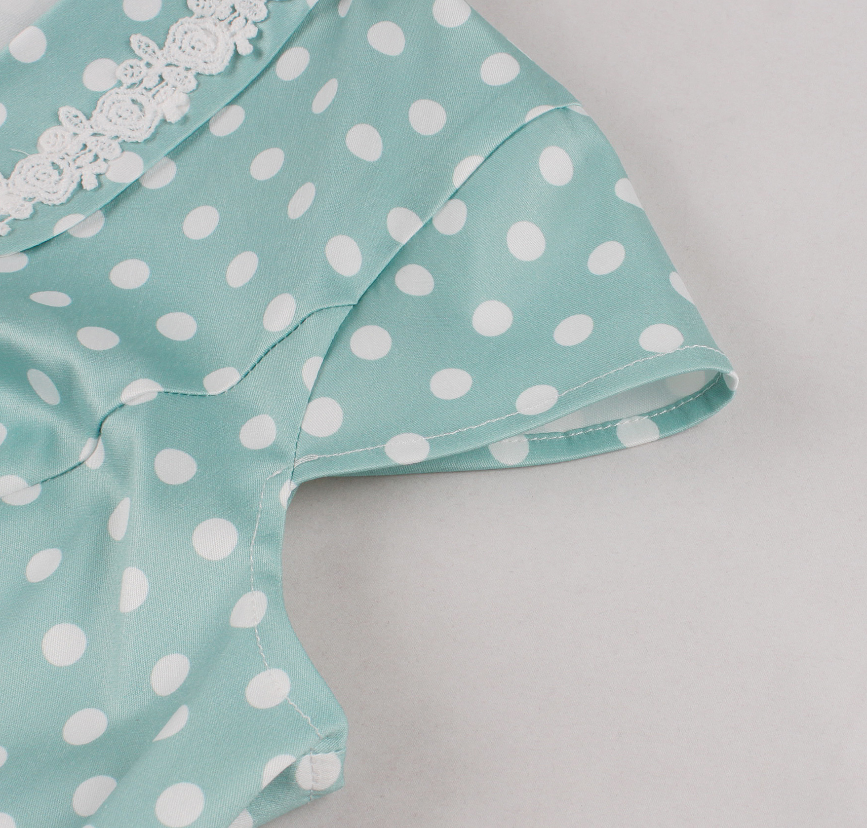 Vintage style, Green with white polka dots, Short sleeves, V-neckline, White lace trim, Chest bow accent, Cinched waist belt, A-line skirt, Lightweight fabric, Comfortable fit #N23827