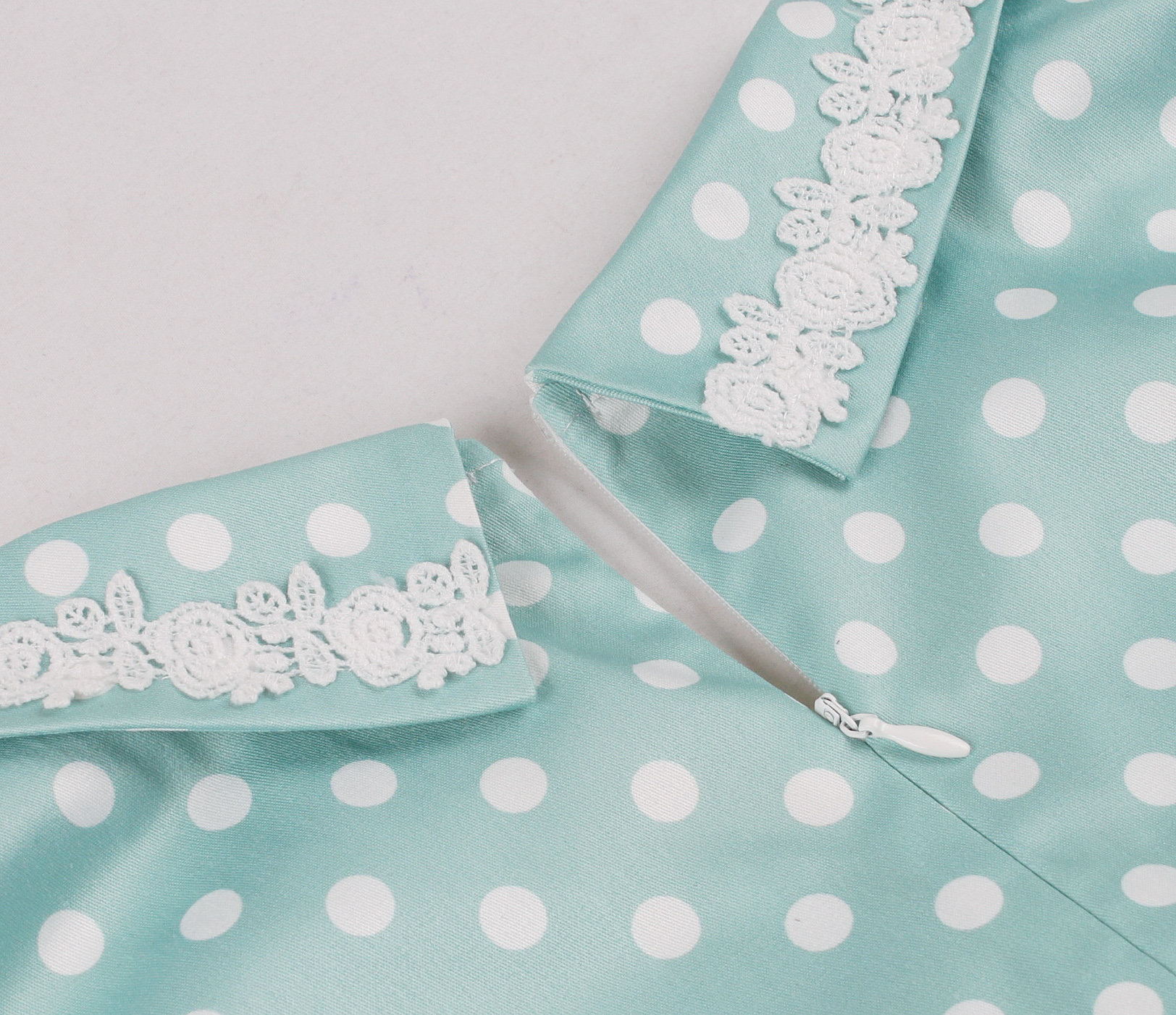 Vintage style, Green with white polka dots, Short sleeves, V-neckline, White lace trim, Chest bow accent, Cinched waist belt, A-line skirt, Lightweight fabric, Comfortable fit #N23827